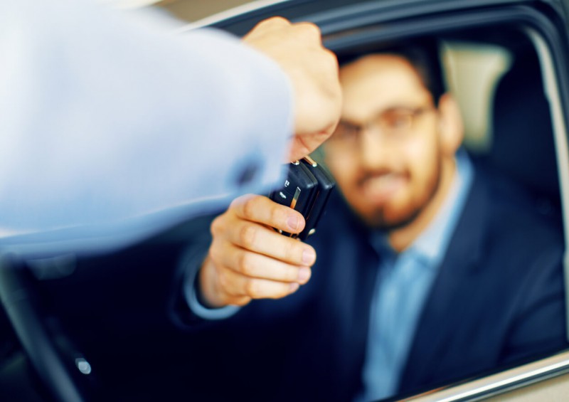 Man handing new car keys over to driver