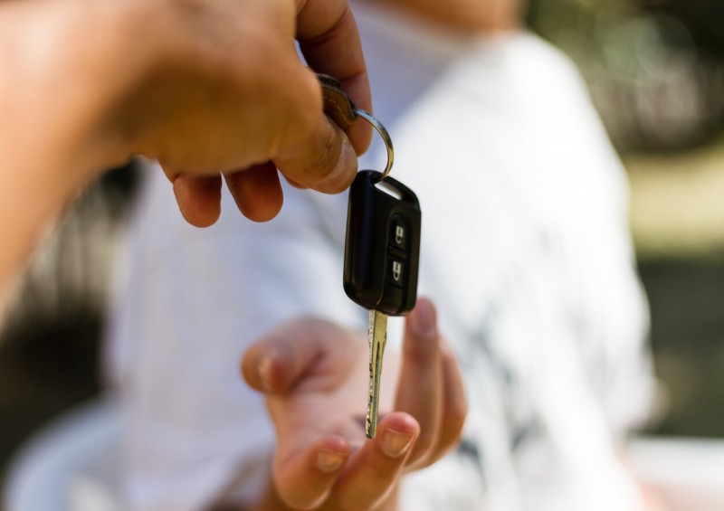 New car key being passed to driver