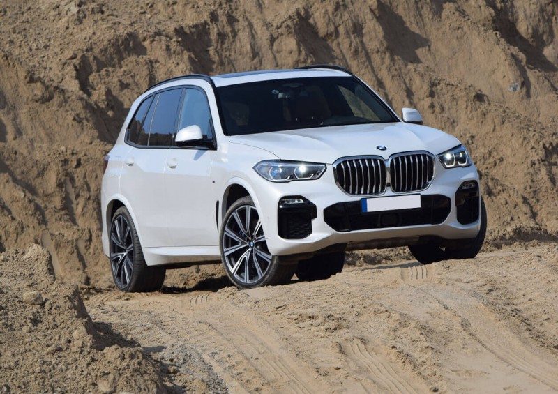 White BMW X5 parked on dunes