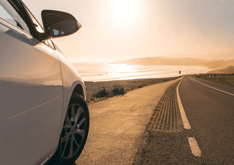 Car pulled over on side of road with beach view