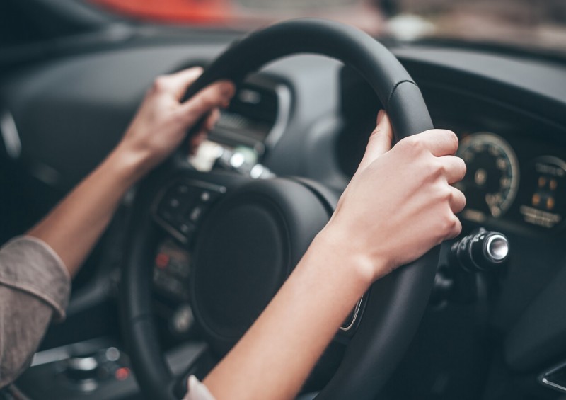 Close up of steering wheel with driver s hands on it