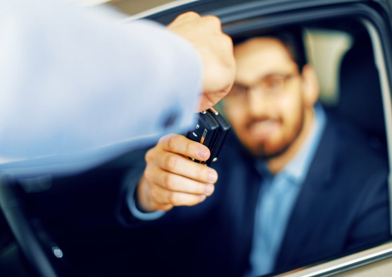 Man handing new car keys over to driver Man handing new car keys over to driver