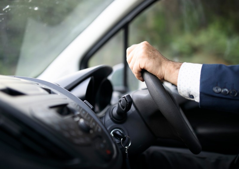 Man in shirt and blazer driving a new van