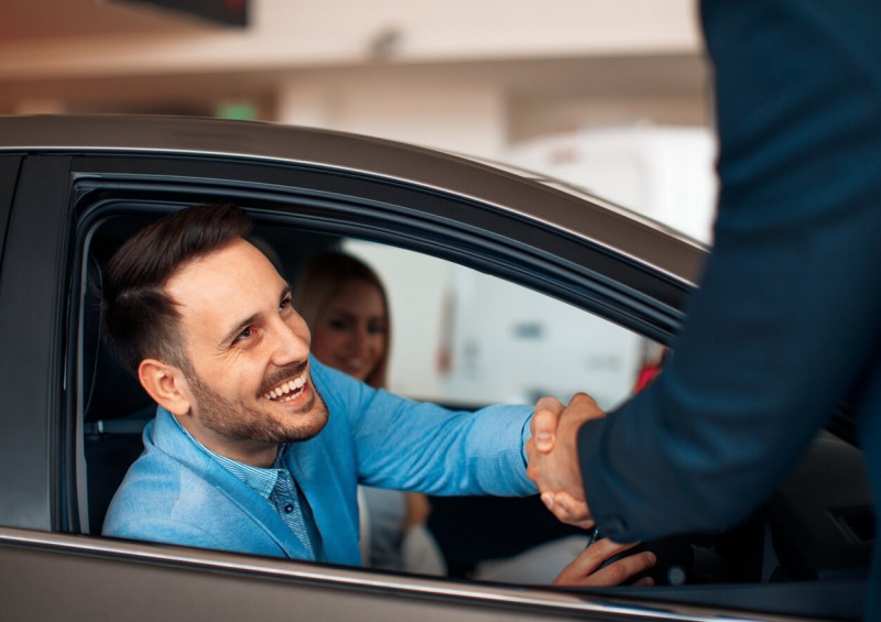 Man shaking hands with car dealer