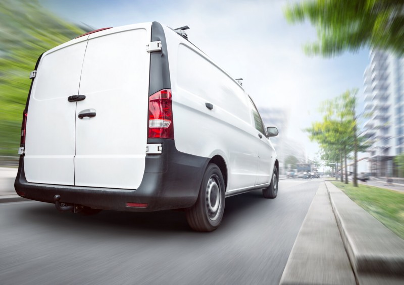 New white van being driven on main road